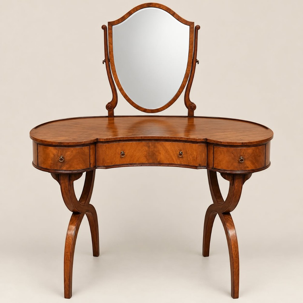 A 1920s kidney-shaped timber dressing table featuring three drawers, sweeping curved legs, and an attached shield-shaped swivel mirror.