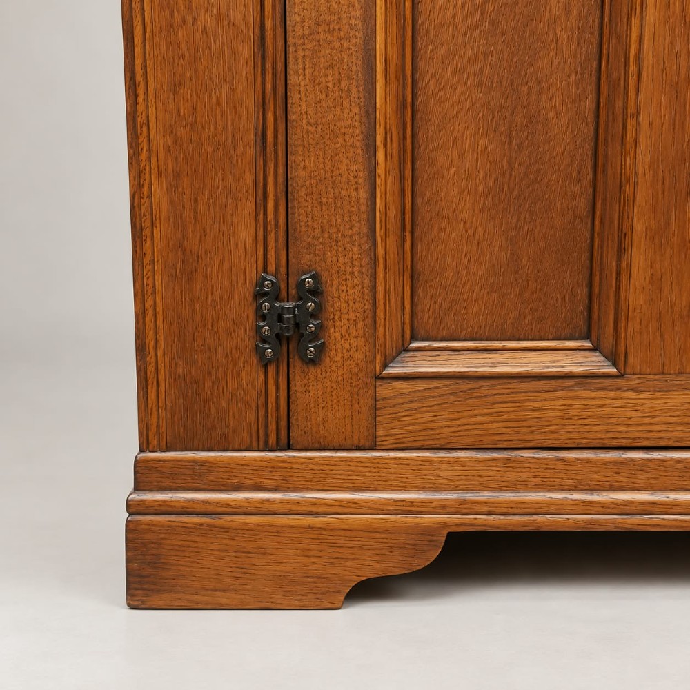 A two-door warm brown oak wardrobe featuring carved diamond motifs on upper panels, recessed rectangular lower panels, and dark iron hardware. View IV