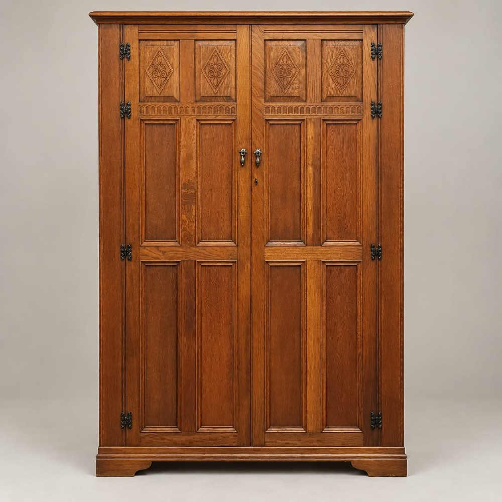 A two-door warm brown oak wardrobe featuring carved diamond motifs on upper panels, recessed rectangular lower panels, and dark iron hardware. View VI