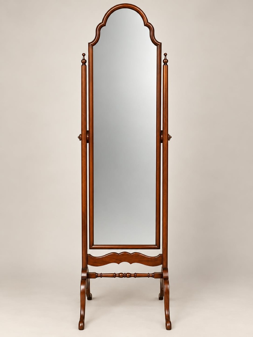 A 1920s full-length mahogany cheval mirror featuring an arched top frame, upright side posts with finials, turned cross-stretcher, and splayed feet.