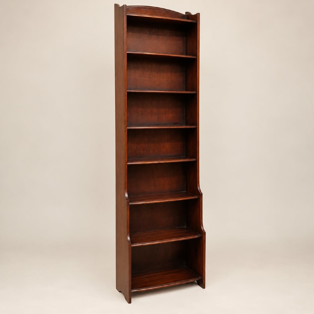 A tall and narrow dark oak waterfall bookcase circa 1920 with six open shelves graduating in depth. View II