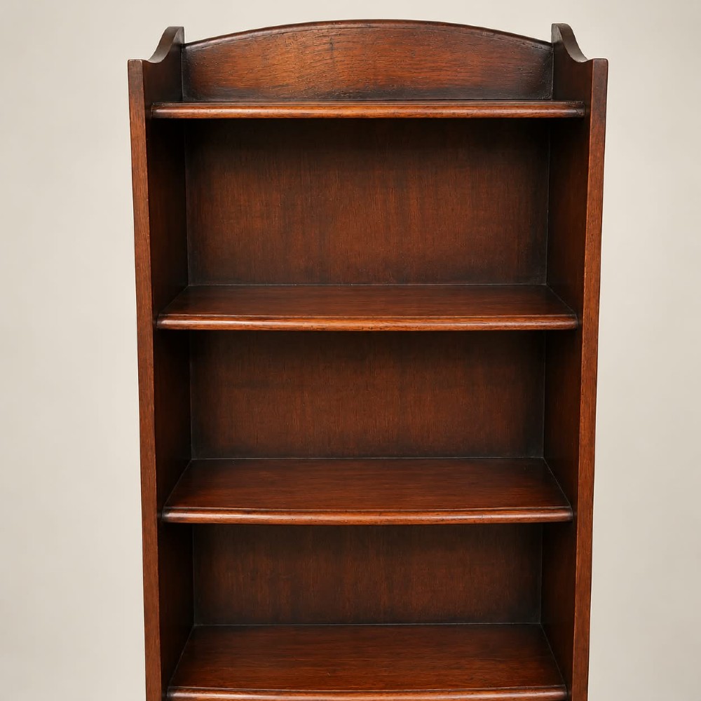 A tall and narrow dark oak waterfall bookcase circa 1920 with six open shelves graduating in depth. View III