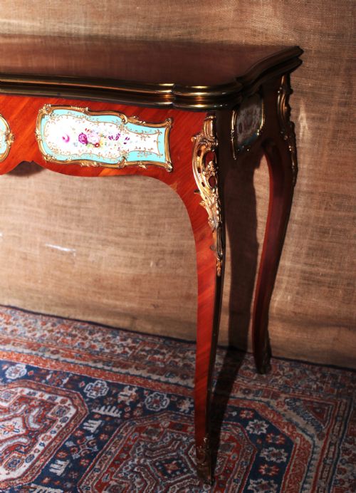 fig 1. A mid-Victorian kingwood games table featuring cabriole legs, ornate gilt-bronze ormolu mounts, and inlaid porcelain plaques depicting floral scenes.