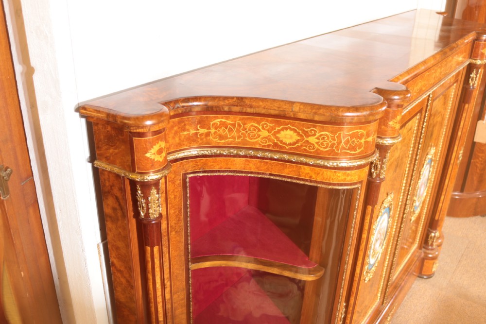 An antique Victorian burr walnut credenza featuring glazed end display doors, intricate marquetry inlay, gilt-metal mounts, and central cabinet doors adorned with oval painted porcelain plaques. View III