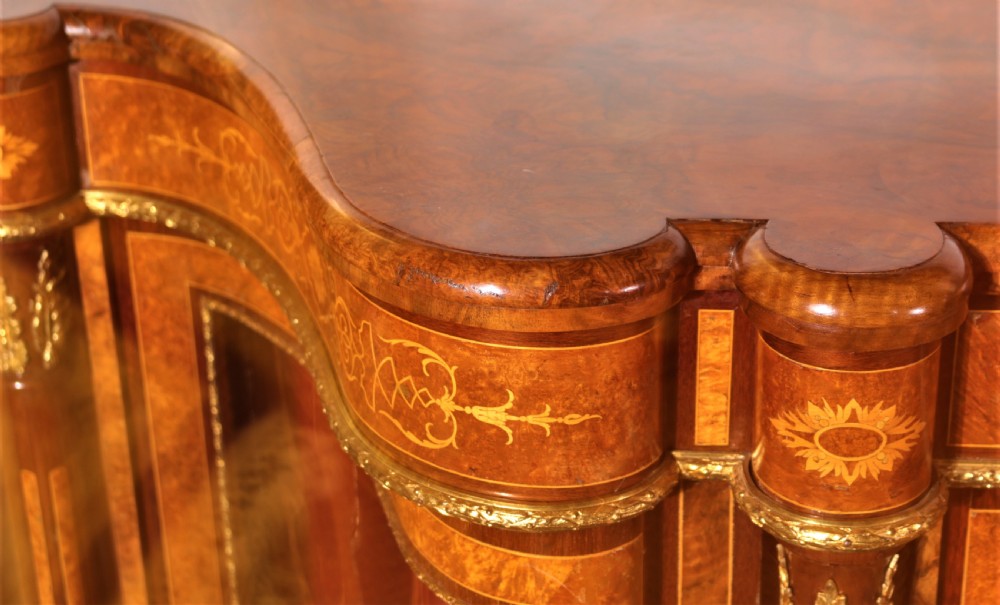 An antique Victorian burr walnut credenza featuring glazed end display doors, intricate marquetry inlay, gilt-metal mounts, and central cabinet doors adorned with oval painted porcelain plaques. View IX