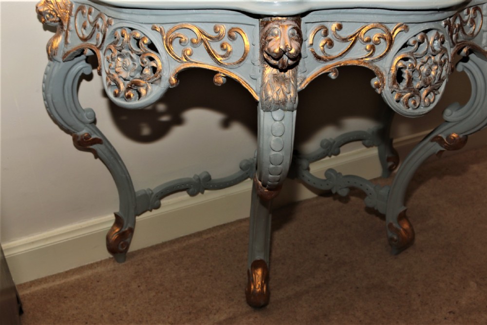 A Mid-Victorian painted grey and parcel-gilt console table featuring an intricate pierced scrollwork crest, lion mask carvings, and cabriole legs. View VII