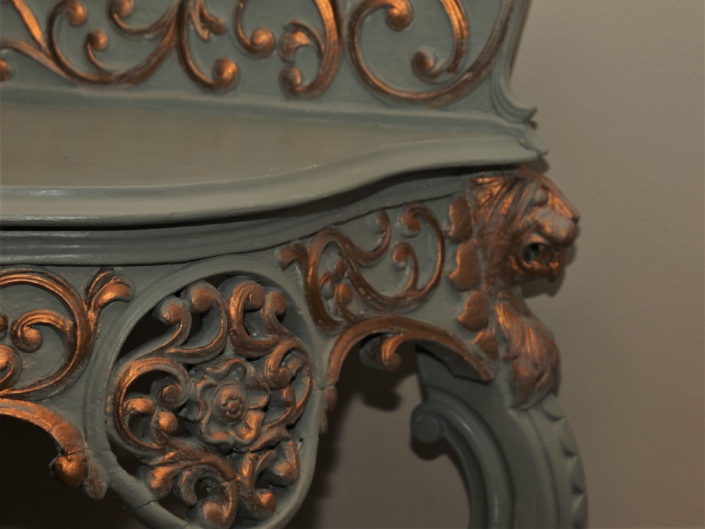 A Mid-Victorian painted grey and parcel-gilt console table featuring an intricate pierced scrollwork crest, lion mask carvings, and cabriole legs. View VIII