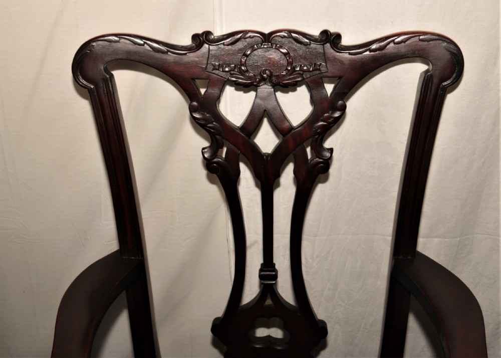 A set of eight dark mahogany Chippendale style dining chairs featuring red upholstered drop-in seats, pierced splats, and carved cabriole legs with ball-and-claw feet. View V