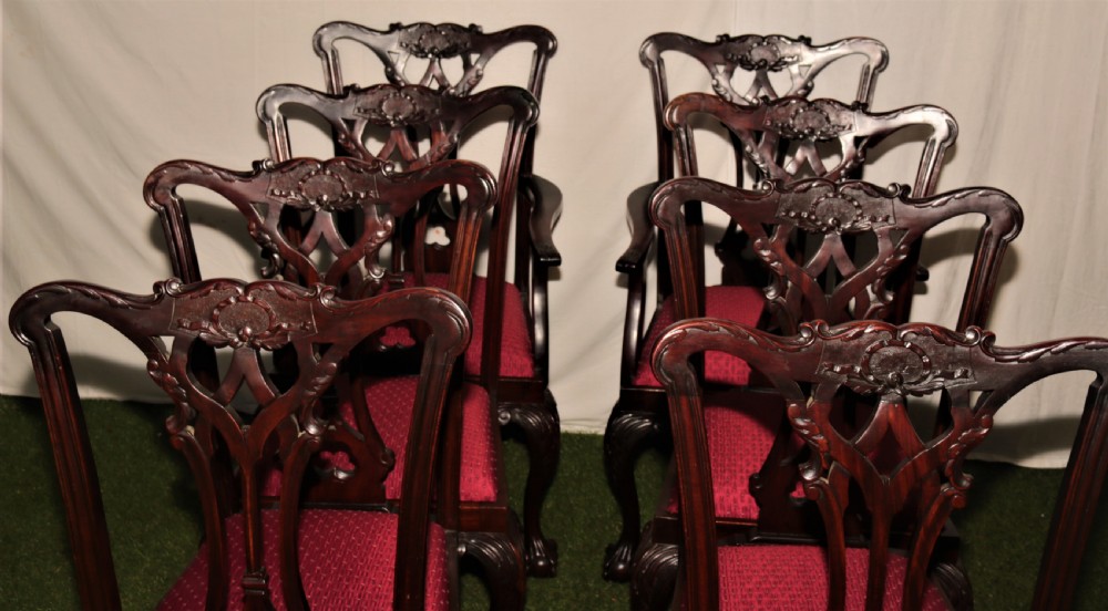 A set of eight dark mahogany Chippendale style dining chairs featuring red upholstered drop-in seats, pierced splats, and carved cabriole legs with ball-and-claw feet. View VII