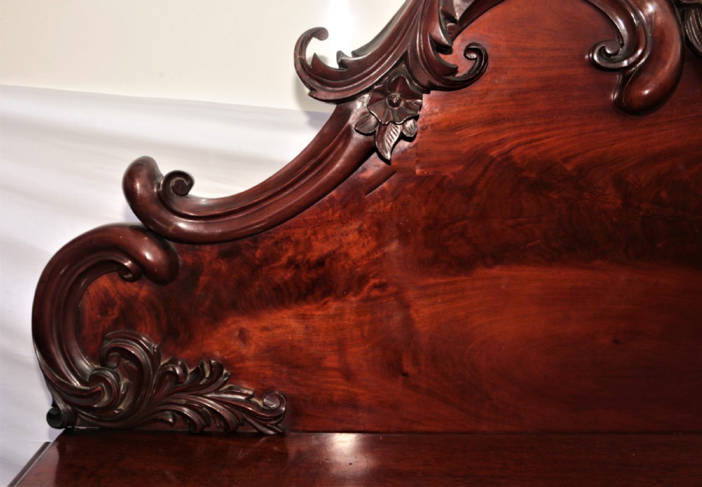 A Victorian dark mahogany sideboard featuring a large carved rococo backboard, flat serving surface, and two pedestal side cupboards. View VIII