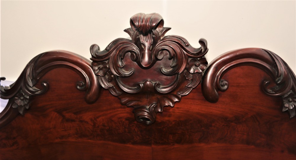 A Victorian dark mahogany sideboard featuring a large carved rococo backboard, flat serving surface, and two pedestal side cupboards. View IX