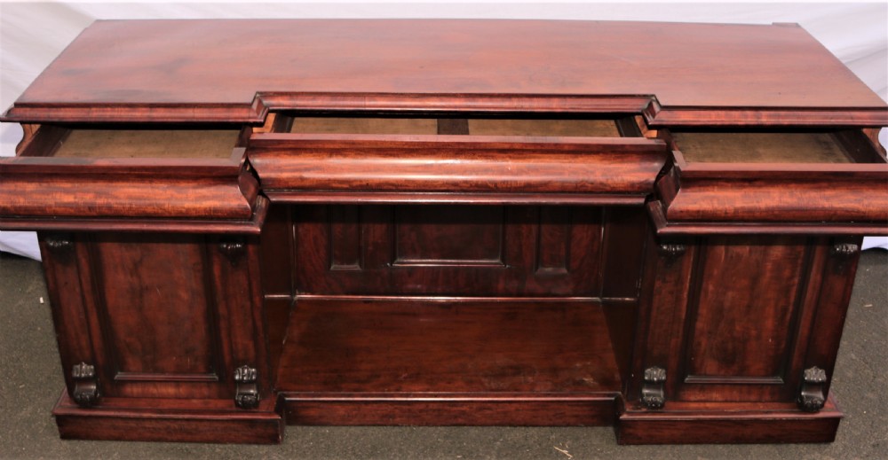 A Victorian dark mahogany sideboard featuring a large carved rococo backboard, flat serving surface, and two pedestal side cupboards. View XI