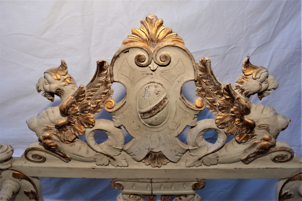 A pair of painted and carved giltwood Savonarola chairs with curved X-frames, ornate carved crests, and yellow patterned fabric seat cushions. View IX