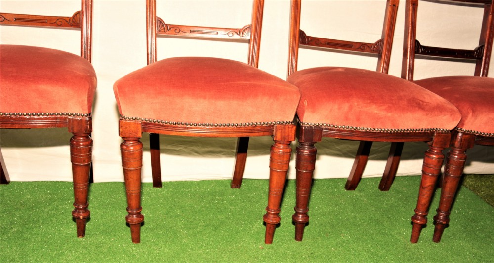 A set of six Victorian mahogany dining chairs featuring carved top rails with turned spindles, turned front legs, and red velvet padded seats. View III