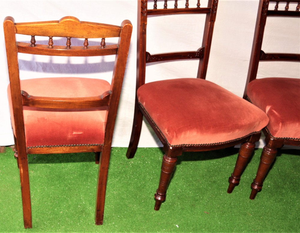 A set of six Victorian mahogany dining chairs featuring carved top rails with turned spindles, turned front legs, and red velvet padded seats. View IV