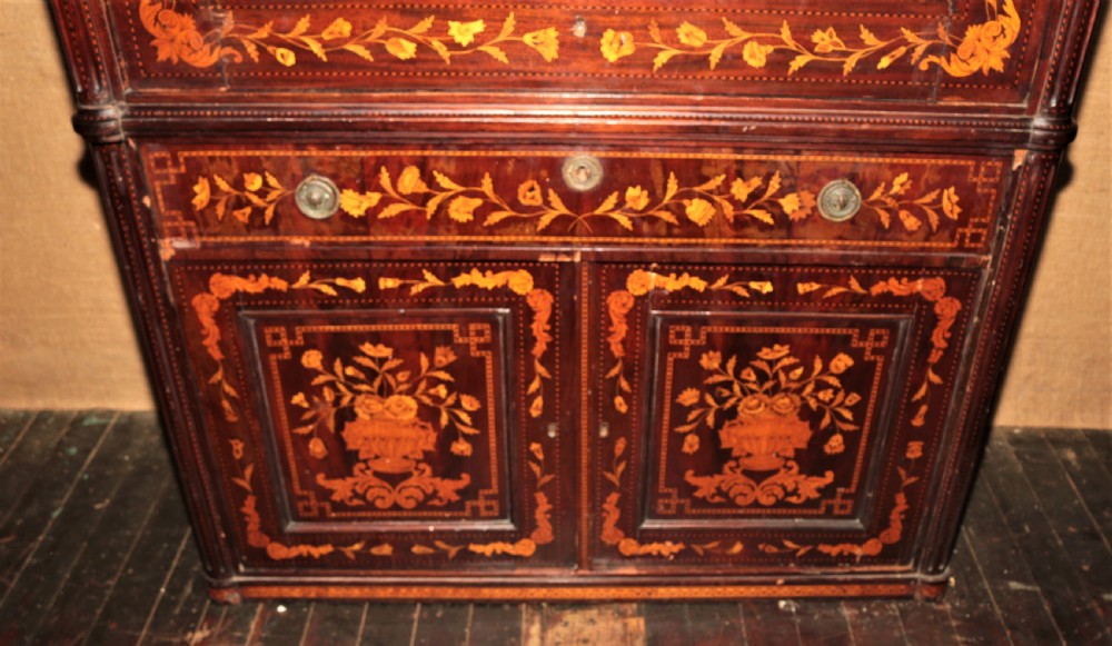 A tall dark mahogany wardrobe decorated with intricate light wood floral marquetry, featuring large panelled upper doors and a lower drawer section. View III