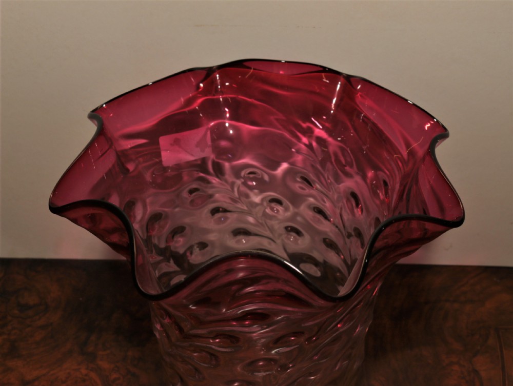 A deep cranberry red hand-blown glass lampshade featuring a dimpled textured body and a wide ruffled crimped rim. View II