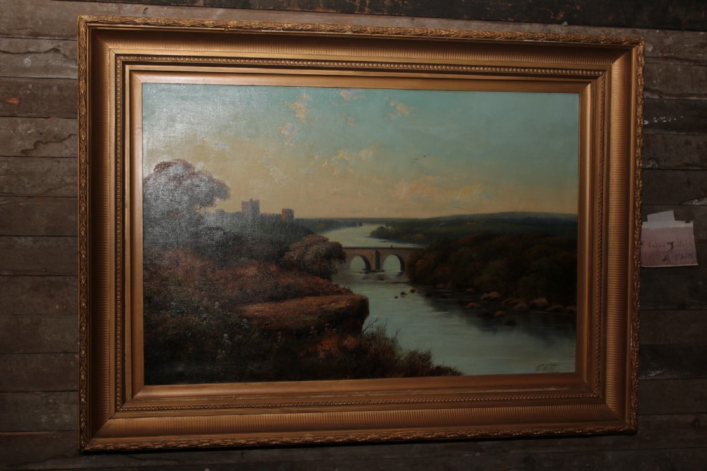 A framed landscape oil painting on canvas depicting Richmond Castle, a stone river bridge, and dense foliage beneath a soft blue sky. View V