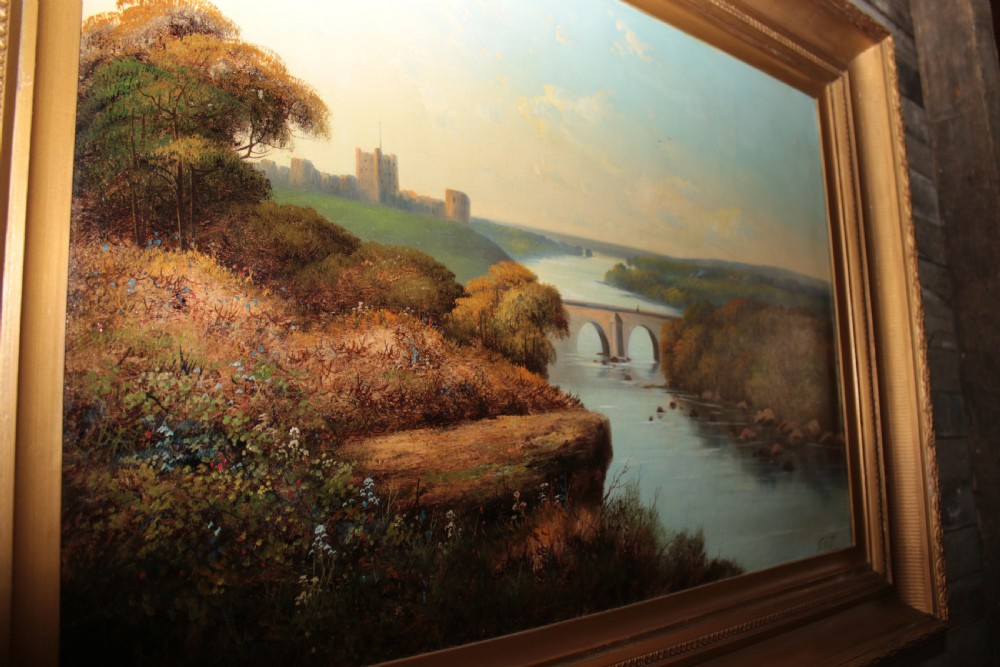 A framed landscape oil painting on canvas depicting Richmond Castle, a stone river bridge, and dense foliage beneath a soft blue sky. View IX