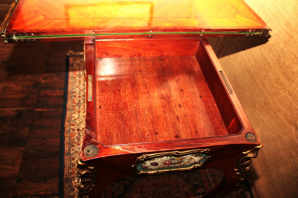 A mid-Victorian kingwood games table featuring cabriole legs, ornate gilt-bronze ormolu mounts, and inlaid porcelain plaques depicting floral scenes. View XXI