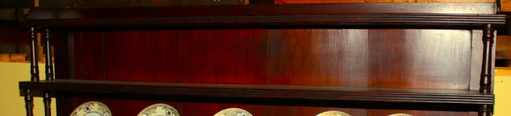 A Regency mahogany waterfall bookcase featuring open graduated shelves with turned spindle columns above a two-door base cupboard. View XI