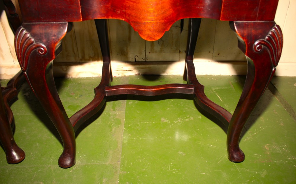 A set of six dark mahogany Queen Anne style dining chairs featuring carved shell crests and red patterned fabric upholstery. View II