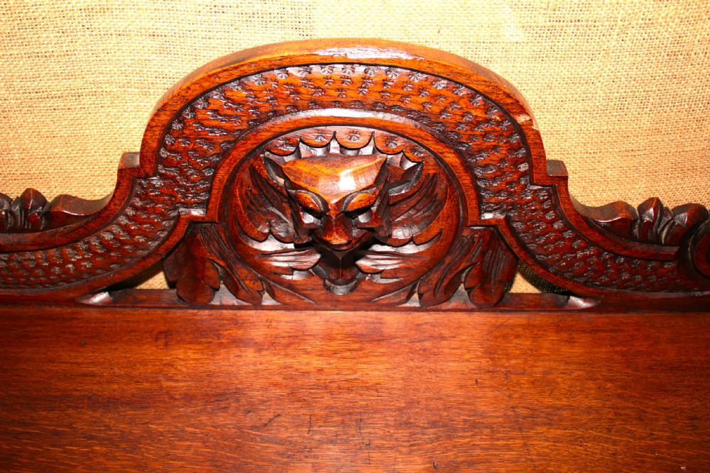 A dark carved oak side table featuring an ornate upstand with a mask motif, an intricately carved apron, and detailed legs. View II