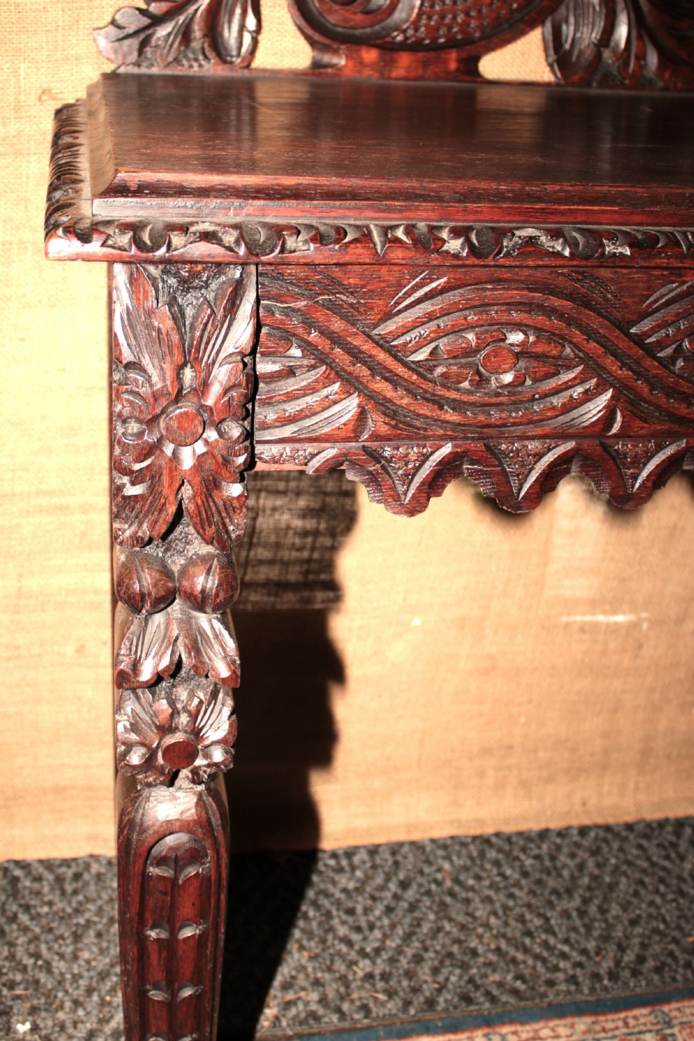 A dark carved oak side table featuring an ornate upstand with a mask motif, an intricately carved apron, and detailed legs. View VIII