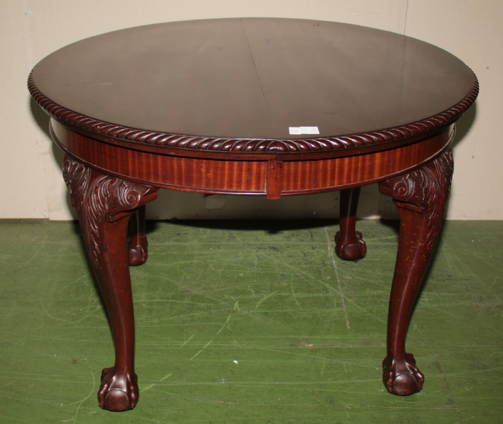 An oval mahogany extendable dining table with carved cabriole legs, ball and claw feet, and a winding handle mechanism. View III