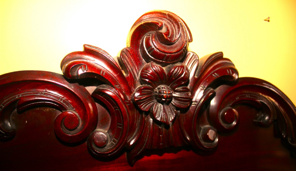 A Victorian mahogany two-door sideboard featuring a carved scrollwork backboard, flame mahogany panels, and a serpentine plinth base. View V