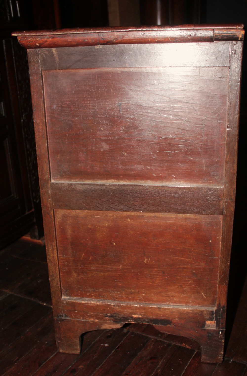 A late seventeenth-century dark oak chest of four drawers featuring raised geometric panel mouldings and brass drop handles. View VIII