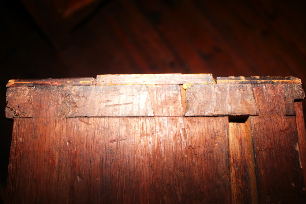 A late seventeenth-century dark oak chest of four drawers featuring raised geometric panel mouldings and brass drop handles. View XIV