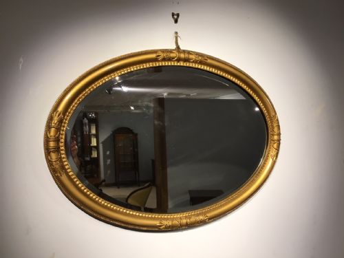 An Oval Edwardian Period Regency Style Gilt Mirror.