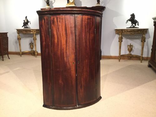 A Mahogany George III Period Bow Front Corner Cupboard