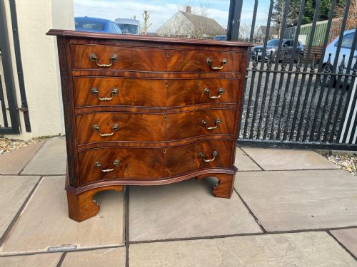 A MAHOGANY CHIPPENDALE REVIVAL SERPENTINE CHEST OF DRAWERS