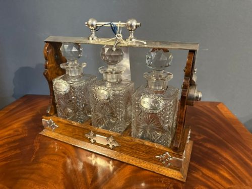 A Late Victorian Period Daniel and Arter Oak Three Bottle Tantalus