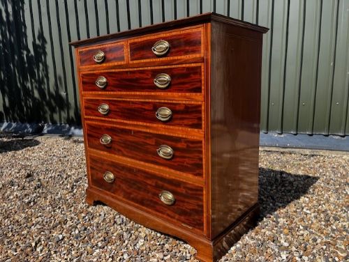 An Edwardian mahogany tall chest featuring two short drawers above four long drawers with satinwood crossbanding and brass oval drop handles. View II