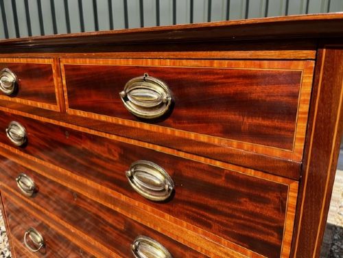 An Edwardian mahogany tall chest featuring two short drawers above four long drawers with satinwood crossbanding and brass oval drop handles. View VI