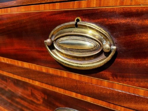 An Edwardian mahogany tall chest featuring two short drawers above four long drawers with satinwood crossbanding and brass oval drop handles. View VII
