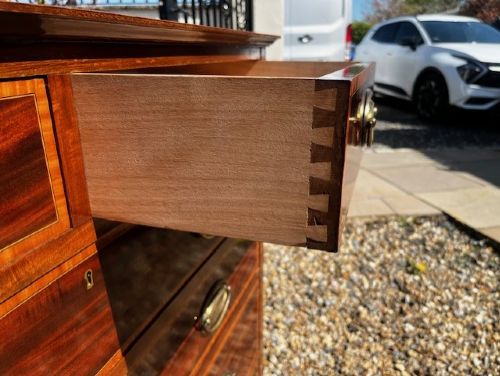 An Edwardian mahogany tall chest featuring two short drawers above four long drawers with satinwood crossbanding and brass oval drop handles. View VIII