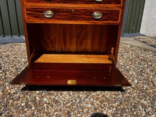 An Edwardian mahogany tall chest featuring two short drawers above four long drawers with satinwood crossbanding and brass oval drop handles. View IX
