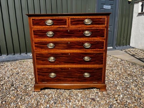 An Edwardian mahogany tall chest featuring two short drawers above four long drawers with satinwood crossbanding and brass oval drop handles. View XI