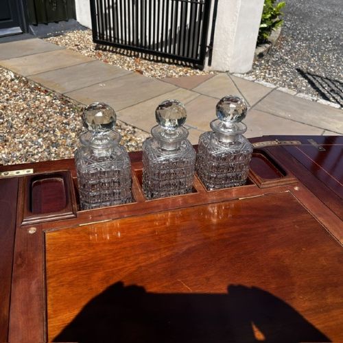 An Edwardian mahogany surprise drinks cabinet featuring satinwood inlay, square tapered legs, a lower shelf, and brass castors. View IV
