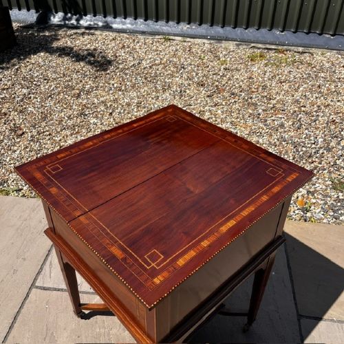 An Edwardian mahogany surprise drinks cabinet featuring satinwood inlay, square tapered legs, a lower shelf, and brass castors. View X