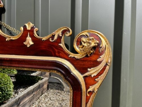 A Chippendale style horizontal wall mirror featuring a polished mahogany frame adorned with carved giltwood scrollwork and a central gilt eagle crest. View IV