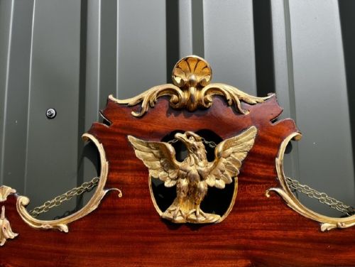A Chippendale style horizontal wall mirror featuring a polished mahogany frame adorned with carved giltwood scrollwork and a central gilt eagle crest. View V