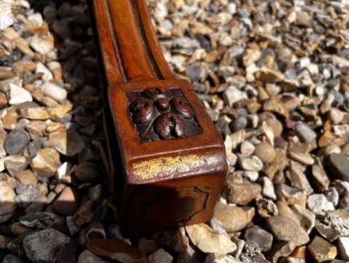 An oval Victorian walnut coffee table featuring a polished figured grain surface and a carved base. View II