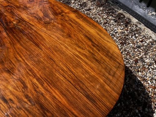An oval Victorian walnut coffee table featuring a polished figured grain surface and a carved base. View VIII