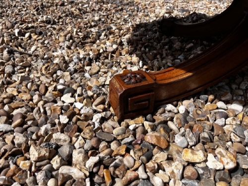 An oval Victorian walnut coffee table featuring a polished figured grain surface and a carved base. View X