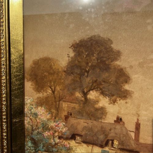 A 19th-century watercolour landscape painting depicting a river scene with boats and cottages, enclosed in an ornate giltwood frame. View V